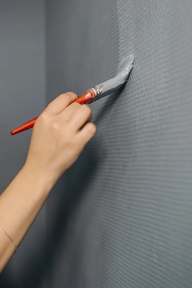 A brush applying a fresh coat to a wall